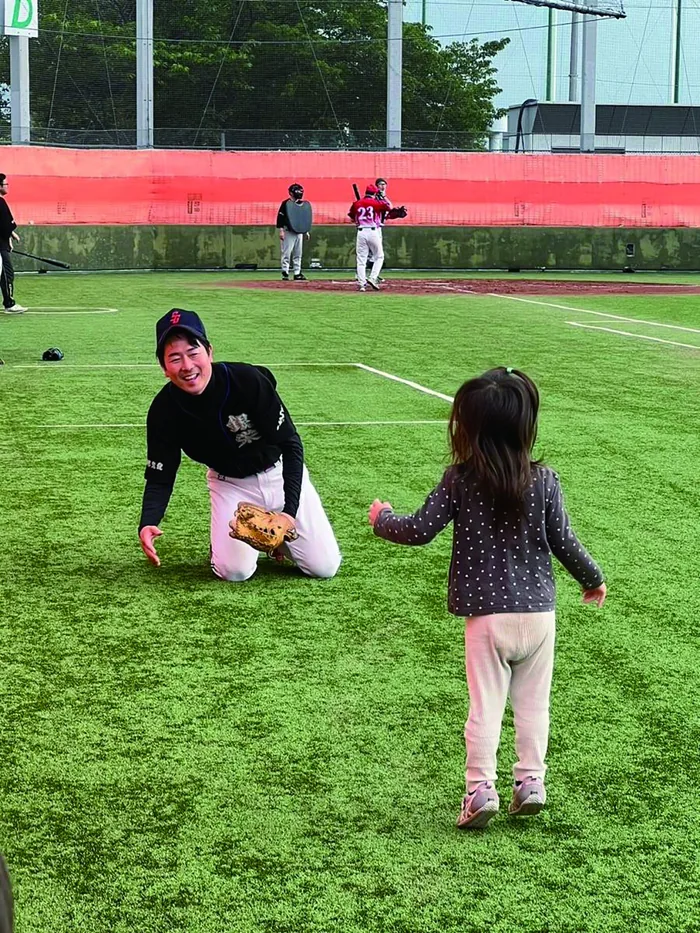 野球場で子供と向き合う大和田伸